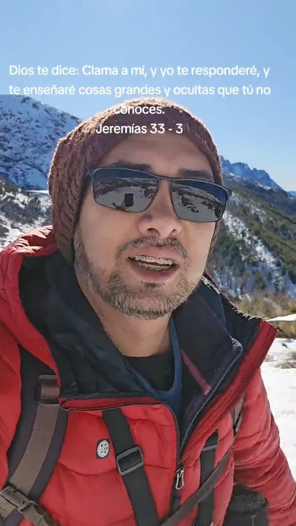 Daniel con chaqueta roja y gorro en la montaña nevada, junto a un versículo de Jeremías 33:3.
